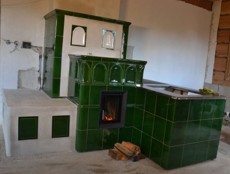 Těžká sálavá kamna v kombinaci se stolovým sporákem. V kachlovém tělese je i prostor pro elektrickou troubu a varnou deskou. Stavba vznikla ve spolupráci s BH Kamnářství.