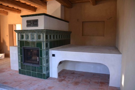 Teplovodní vložka s kachlovou obestavbou v kombinaci s omítaným sporákem zajistí tepelný komfort v celém domě a možnost uvařít si a ohřát se, nezávisle na eletrické energii. Stavba vznikla ve spolupráci s BH Kamnářství.