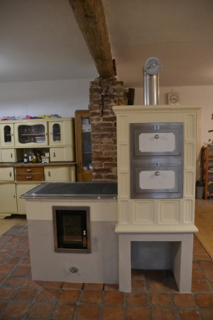 Volně stojící kachlový sporák s prosklenými dvířky od firmy Jokr. Kachle v oblíbené glazuře "Slonová kost". Stavba vznikla ve spolupráci s BH Kamnářství.